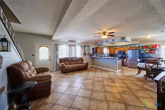 a living room with lots of furniture and kitchen view