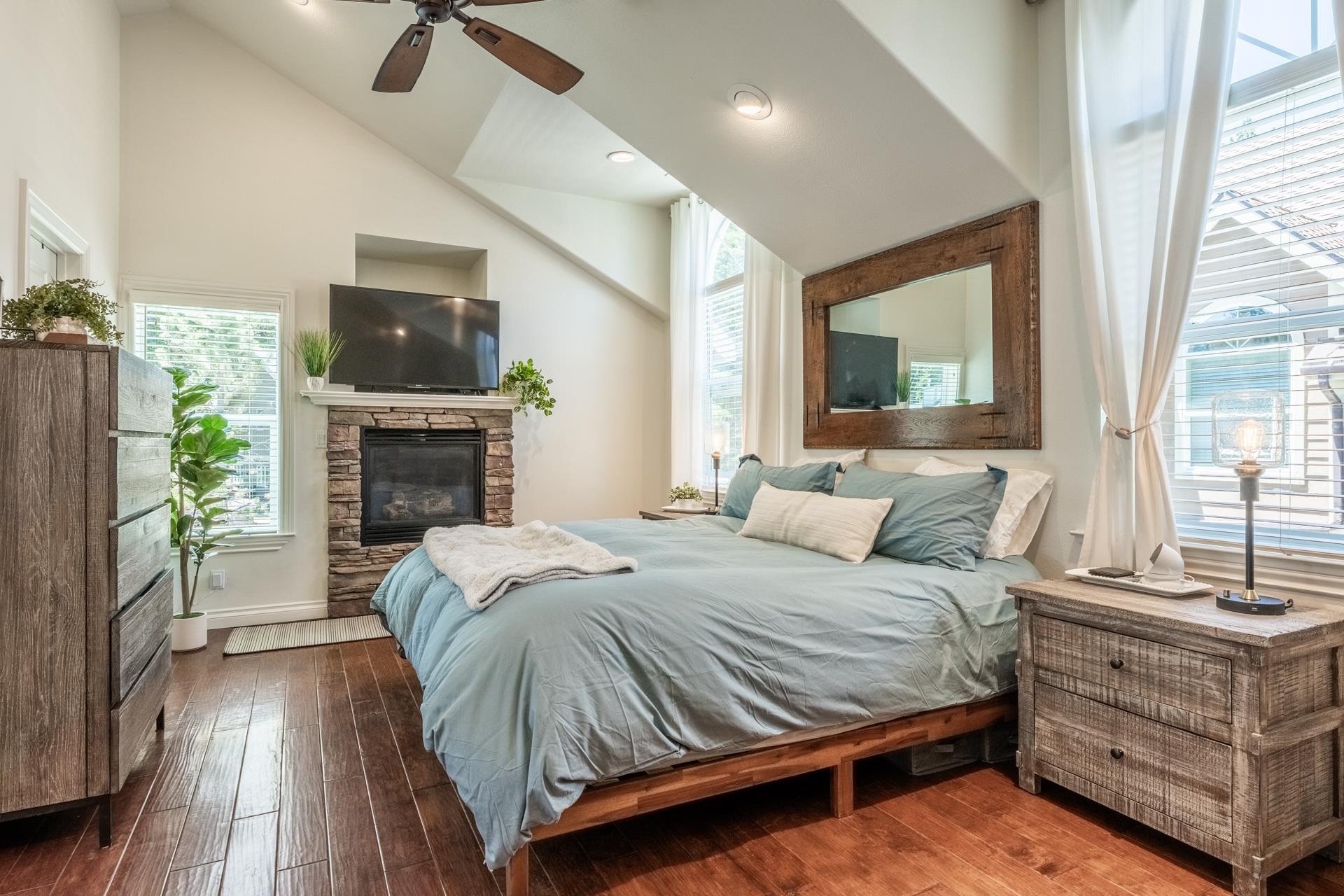 1787 Old Mammoth Road, Unit 2 Mammoth Lakes, CA 93546 - Photo 14 of 29 Vaulted ceiling bedroom featuring wood-finish flooring, a stone-front fireplace with mantel, and a c