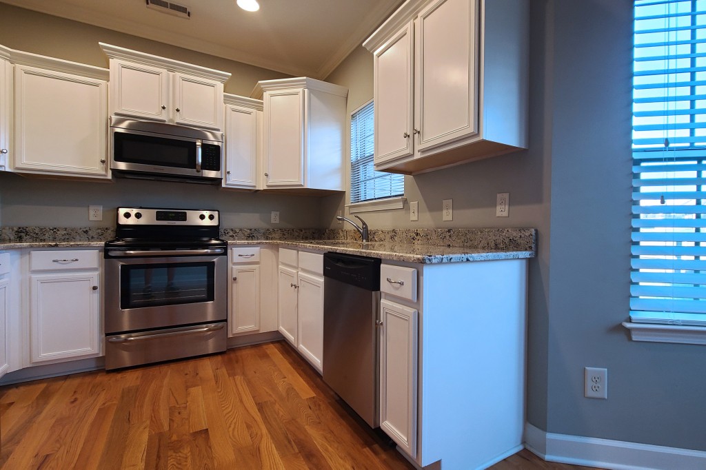1077 Golf View Way Spring Hill, TN 37174 - Photo 5 of 32 a kitchen with stainless steel appliances granite countertop a stove a microwave and a white cabinets