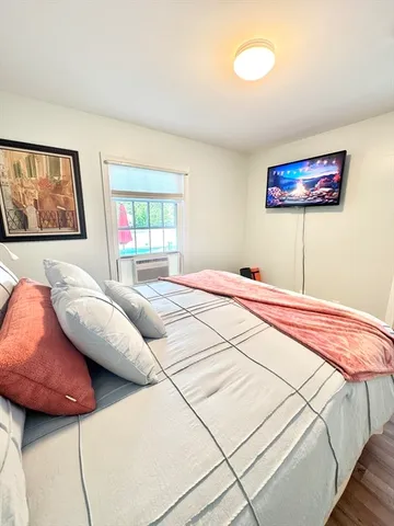 a bedroom with a bed and a large window