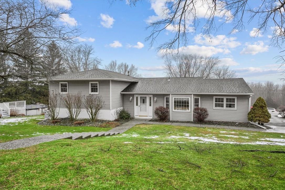 a view of a house with a yard and large tree