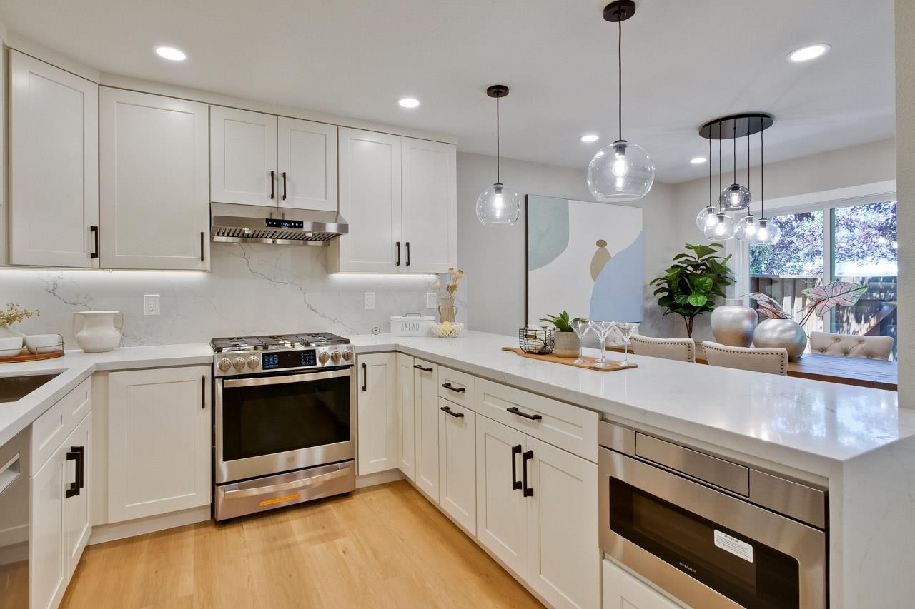 10993 Northsky Square Cupertino, CA 95014 - Photo 13 of 48 a kitchen with stainless steel appliances granite countertop a sink a stove and a wooden floors