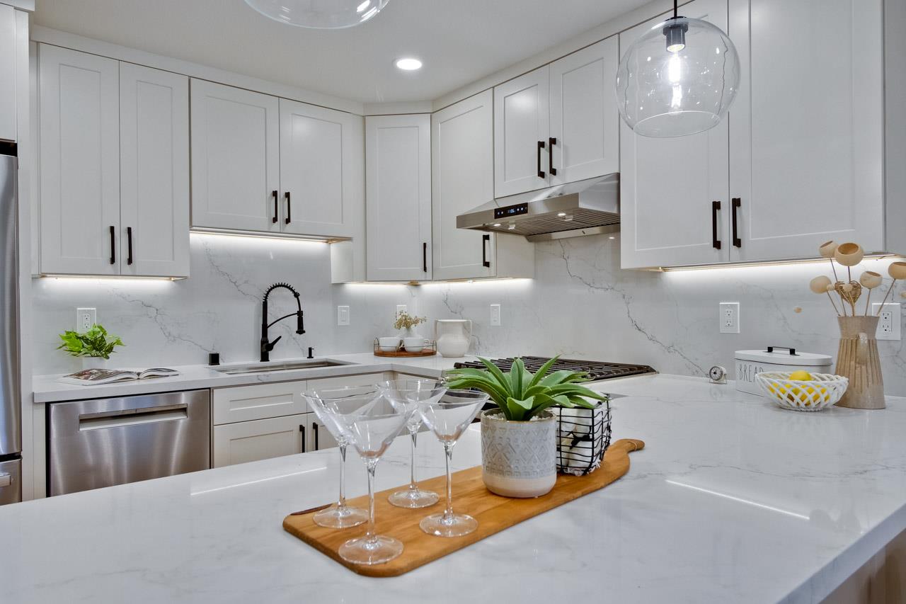 10993 Northsky Square Cupertino, CA 95014 - Photo 17 of 48 a kitchen with stainless steel appliances granite countertop a sink a stove and a wooden floors