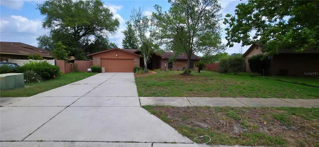 a front view of a house with a yard and trees