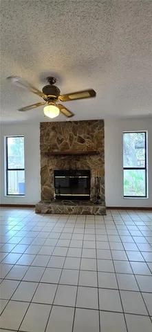 a view of an empty room with a fireplace and a window