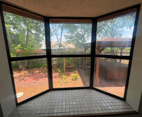 a view of a room with wooden floor and a floor to ceiling window