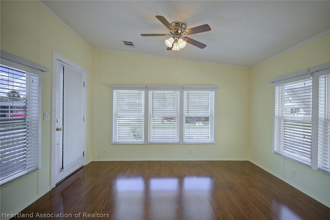 2702 Rodney Street Sebring, FL 33872 - Photo 5 of 33 a view of an empty room with wooden floor and a window