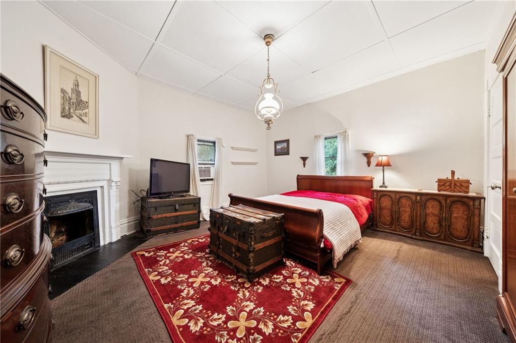 1035 Linden Road Eighty Four, PA 15330 - Photo 24 of 29 a spacious bedroom with a bed a fireplace and a chandelier