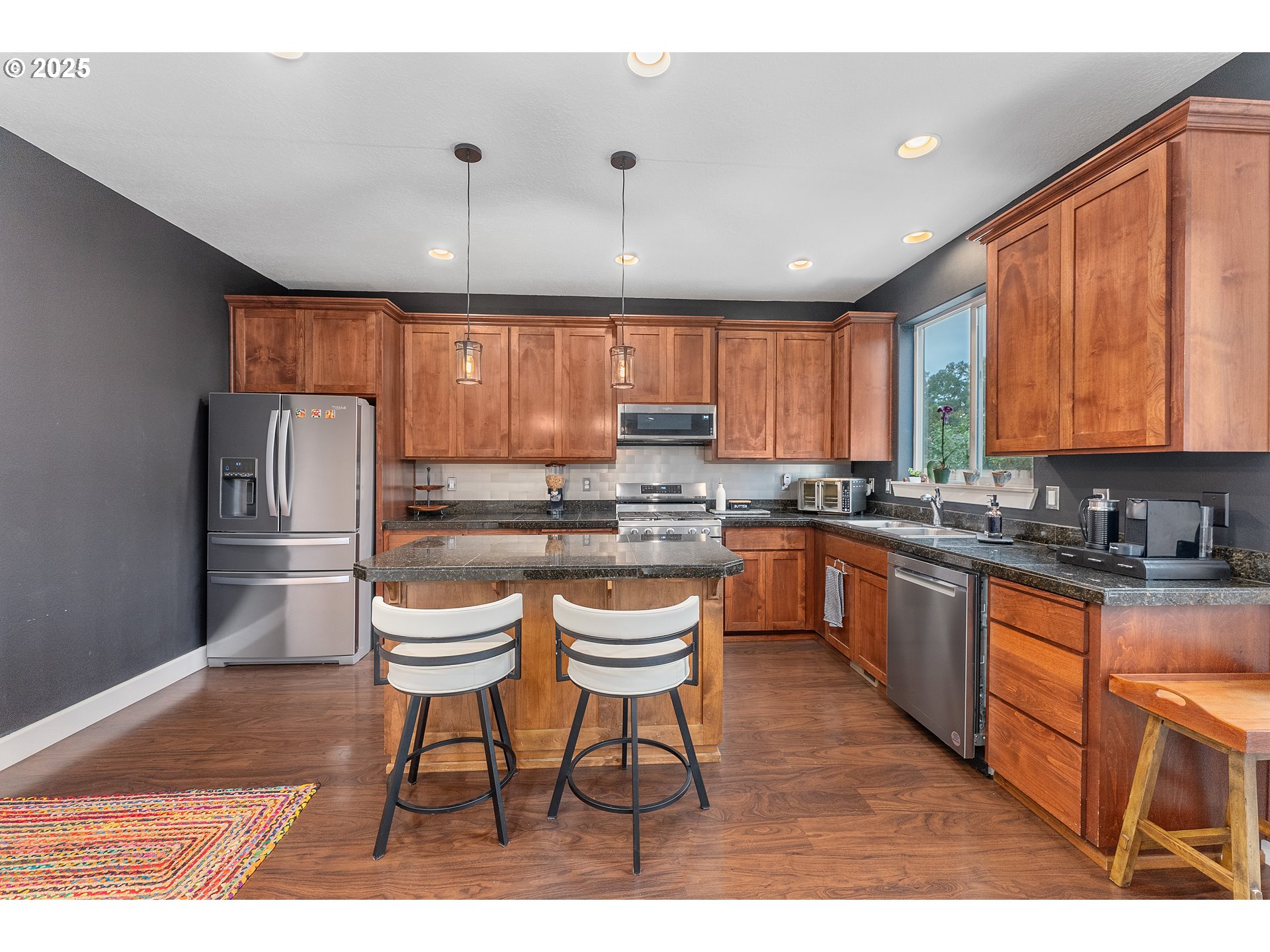 2264 Equestrian Loop South Salem, OR 97302 - Photo 11 of 34 a kitchen with stainless steel appliances granite countertop a sink a stove a refrigerator cabinets and dining table