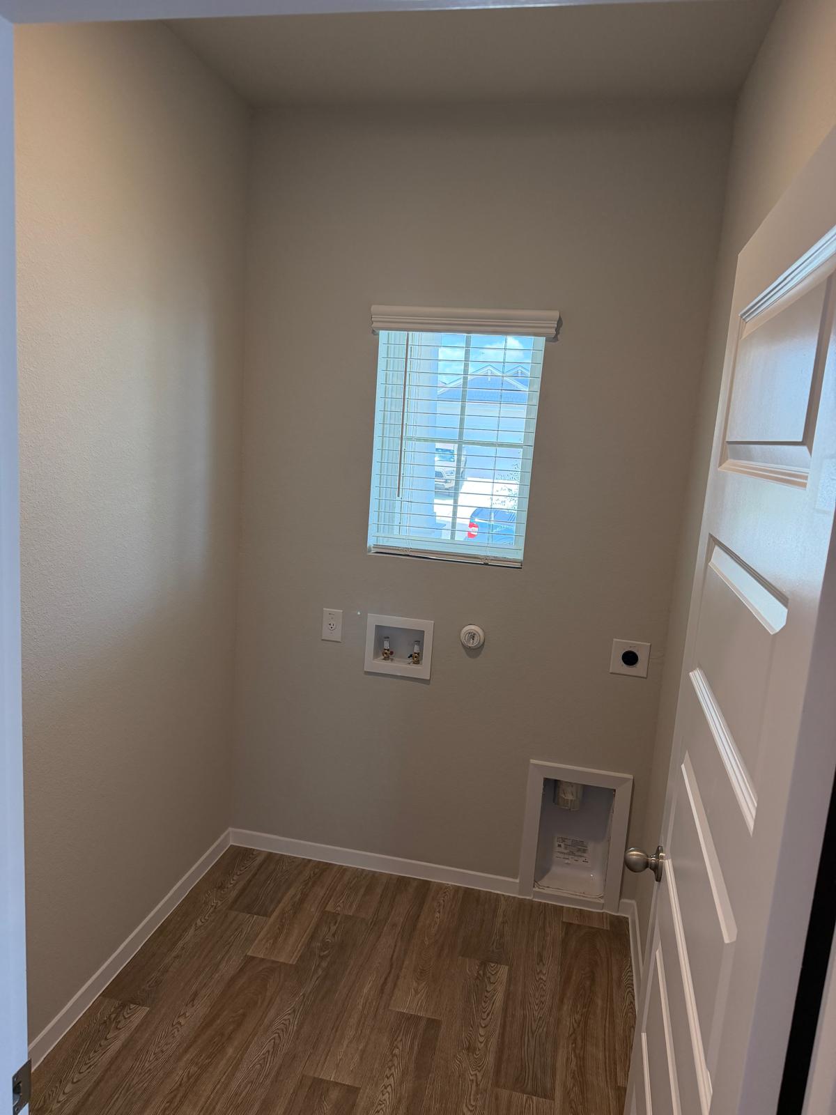2701 Towy Road Manor, TX 78653 - Photo 13 of 35 A dedicated laundry space featuring wood-look flooring and ample natural light from the window.