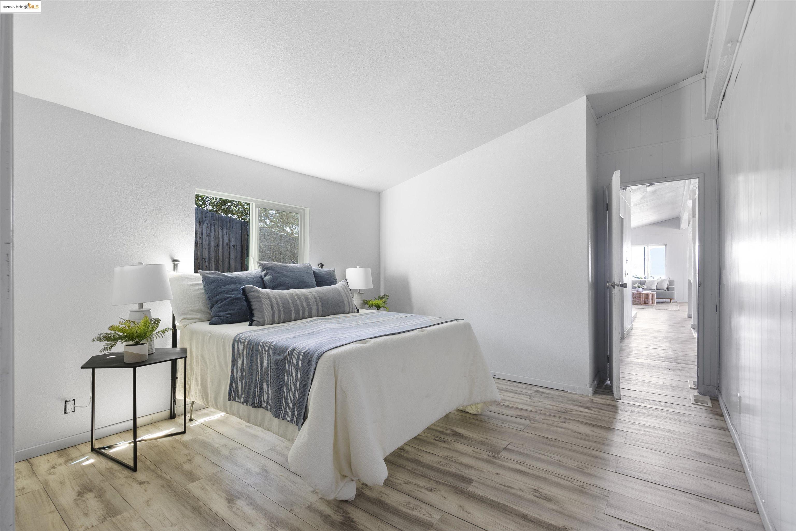 3215 Knob Street Nice, CA 95464 - Photo 20 of 35 a bedroom with a bed and potted plants with wooden floor