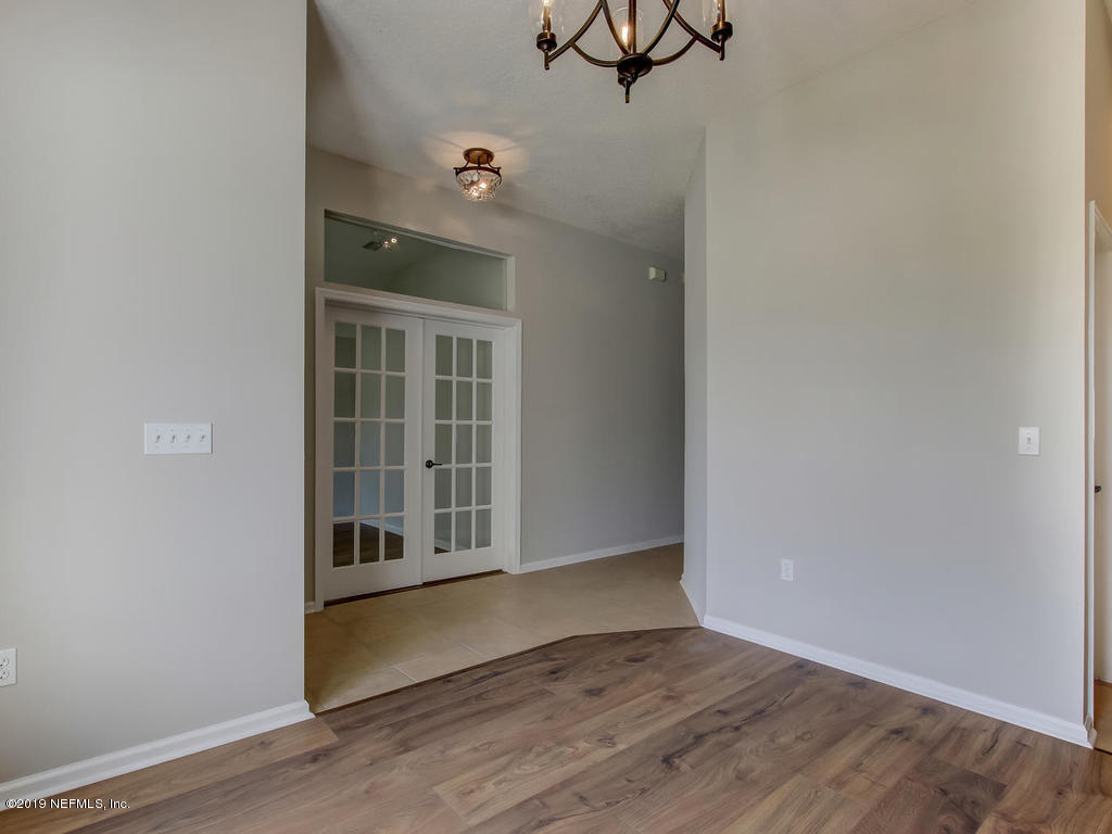 648 Porta Rosa Circle St. Augustine, FL 32092 - Photo 15 of 59 an empty room with wooden floor chandelier and windows