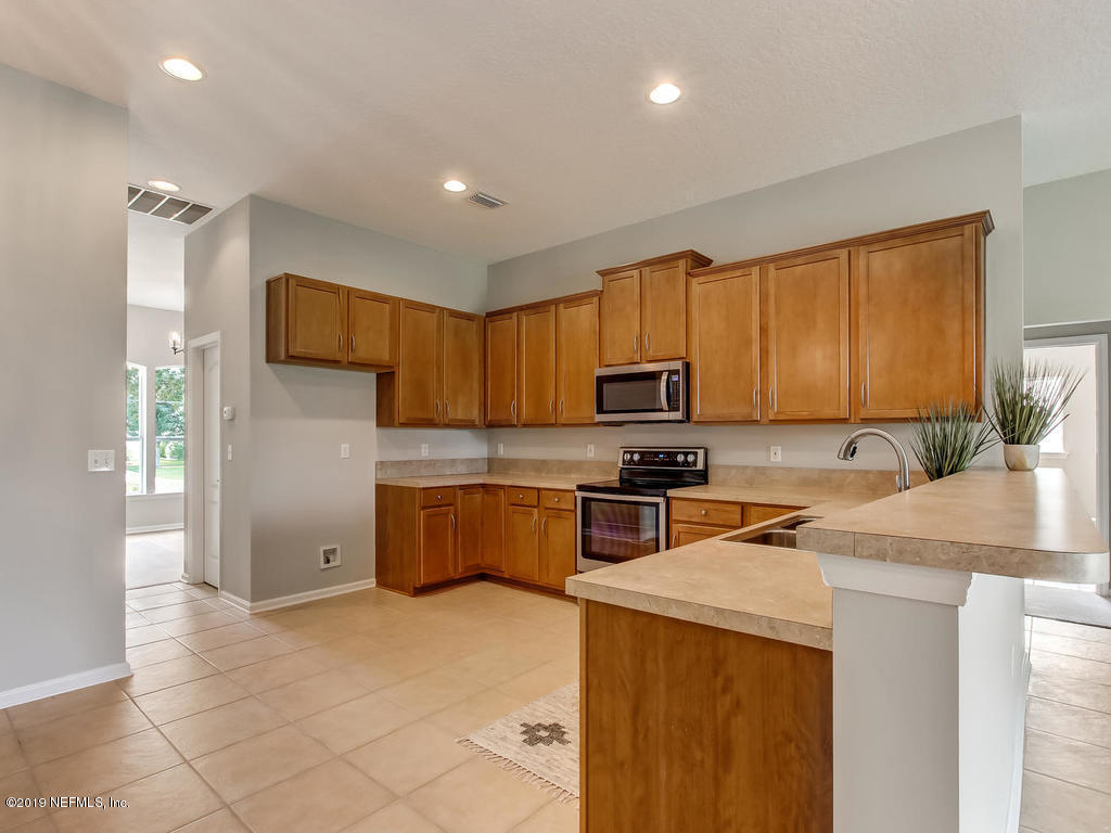 648 Porta Rosa Circle St. Augustine, FL 32092 - Photo 16 of 59 a kitchen with a sink a counter top space cabinets and stainless steel appliances