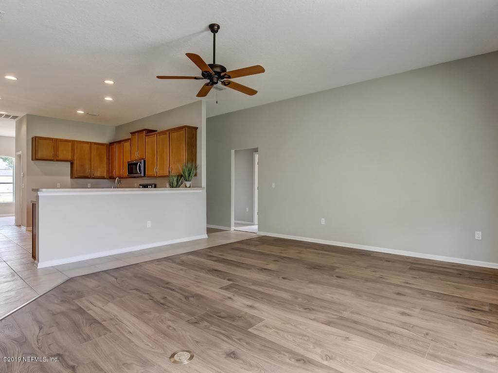 648 Porta Rosa Circle St. Augustine, FL 32092 - Photo 27 of 59 a view of a kitchen with a sink a refrigerator a ceiling fan and wooden floor