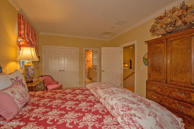 a bedroom with a bed and dresser with mirror