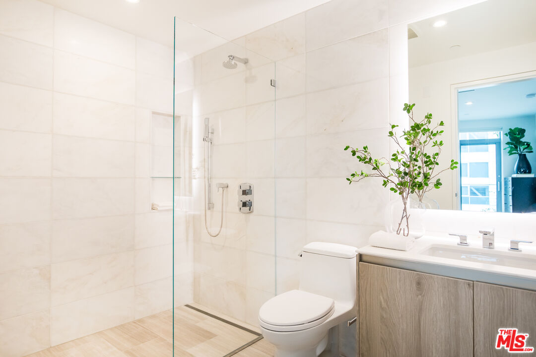8600 Wilshire Boulevard, Unit GF15 Beverly Hills, CA 90211 - Photo 12 of 26 a bathroom with a granite countertop sink a toilet and shower
