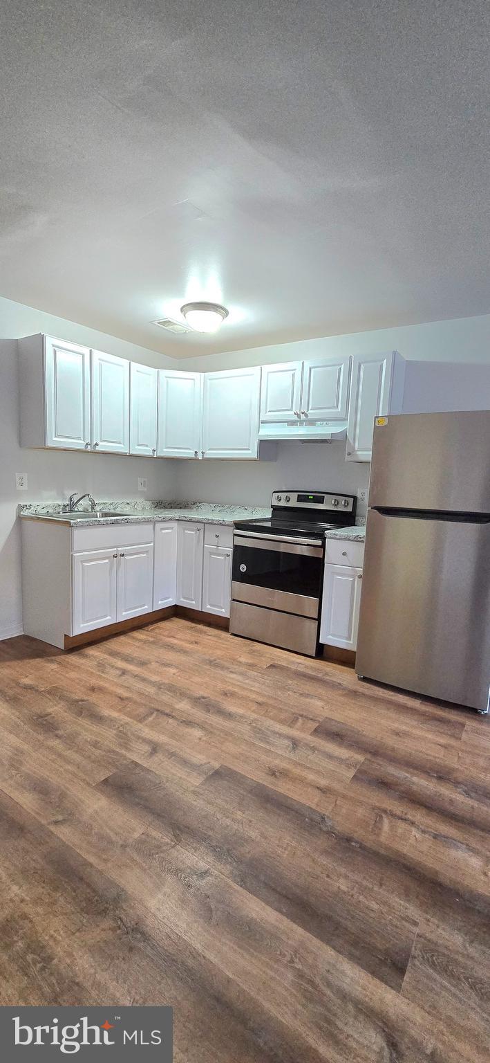 4641 6th Street Southeast Washington, DC 20032 - Photo 2 of 6 a view of kitchen with cabinets and wooden floor