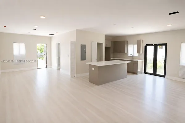 a view of a big room with wooden floor and windows