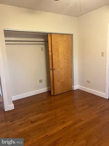 an empty room with wooden floor and closet