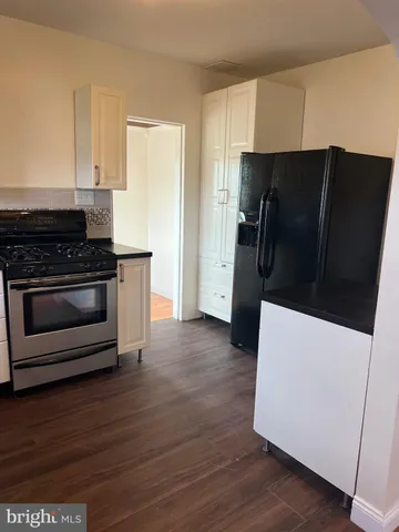 a kitchen with a refrigerator stove and wooden cabinets