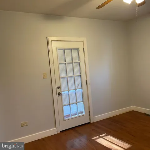 an empty room with wooden floor and door
