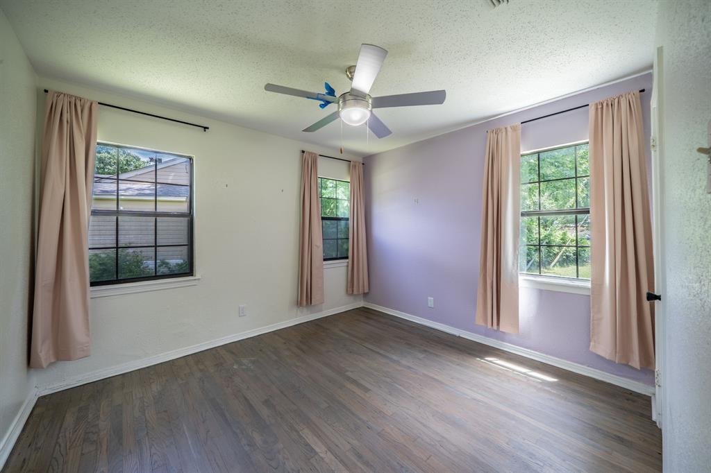 11528 Sinclair Avenue Dallas, TX 75218 - Photo 12 of 16 Spacious room featuring wood-finish flooring, multiple windows with natural light, and a ceiling fan