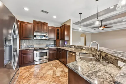 a kitchen with stainless steel appliances granite countertop a sink stove and refrigerator