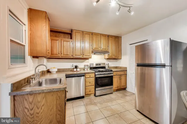 a kitchen with stainless steel appliances granite countertop a refrigerator sink and stove