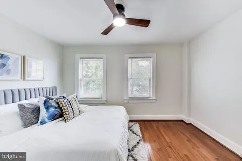 a bedroom with a large bed and wooden floor
