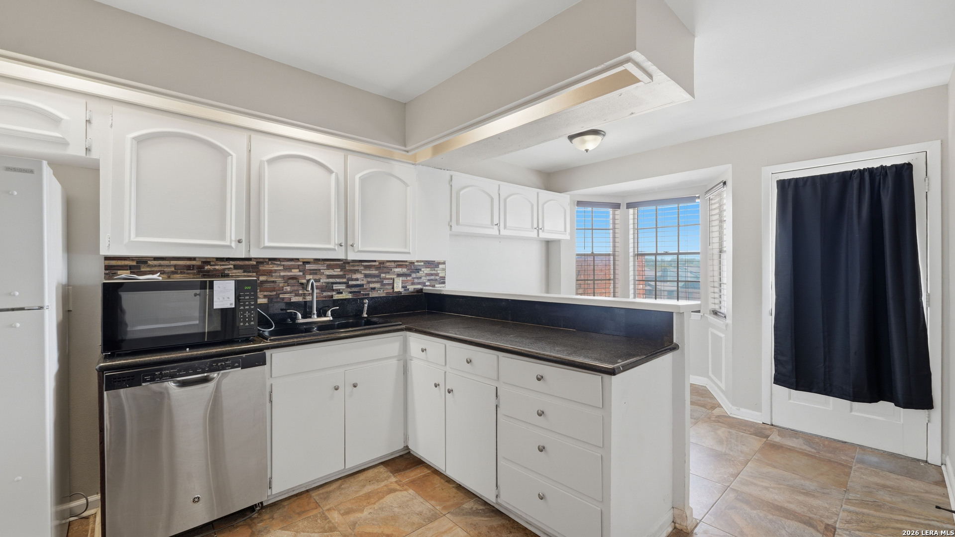 7500 Callaghan Road, Unit 140 San Antonio, TX 78229 - Photo 13 of 42 a kitchen with granite countertop white cabinets and stainless steel appliances