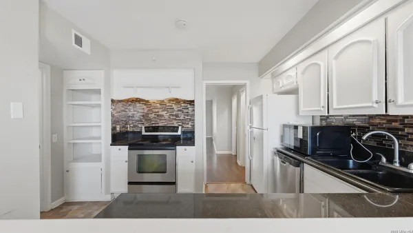 a kitchen with granite countertop white cabinets and window