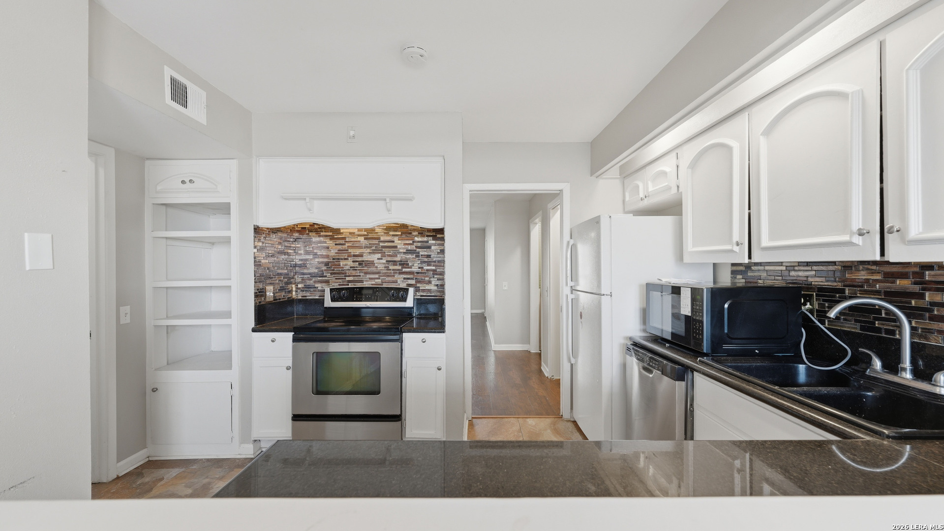 7500 Callaghan Road, Unit 140 San Antonio, TX 78229 - Photo 15 of 42 a kitchen with stainless steel appliances granite countertop a stove and a refrigerator