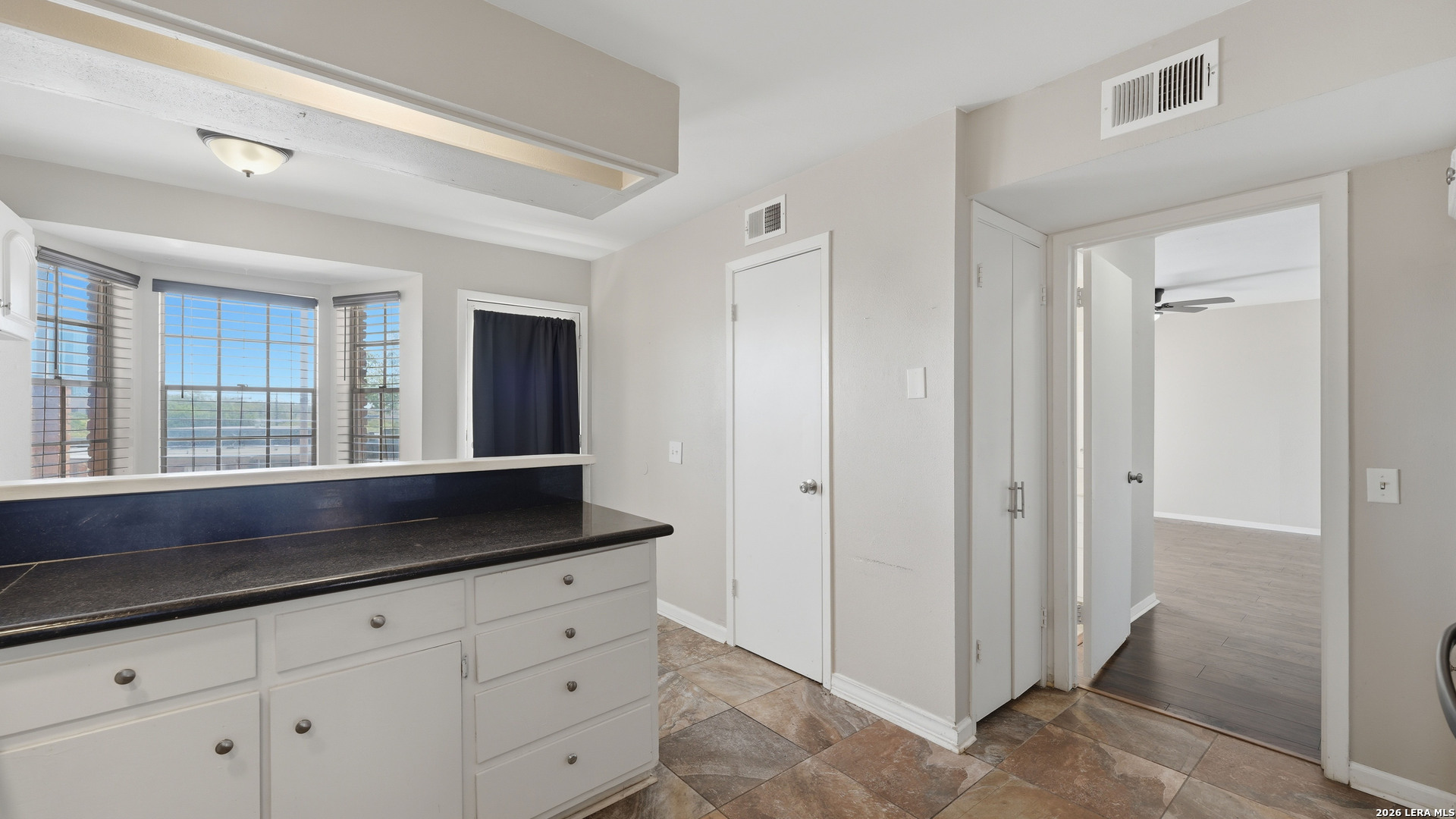 7500 Callaghan Road, Unit 140 San Antonio, TX 78229 - Photo 16 of 42 a kitchen with granite countertop white cabinets and window