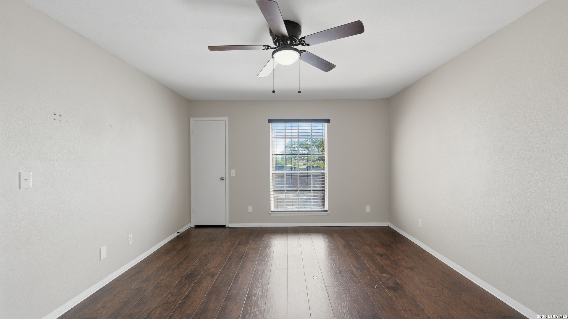 7500 Callaghan Road, Unit 140 San Antonio, TX 78229 - Photo 23 of 42 an empty room with wooden floor chandelier fan and windows
