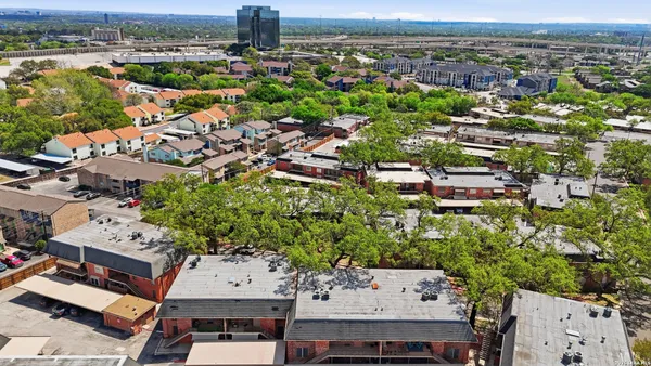 an aerial view of a house with balcony and trees al around