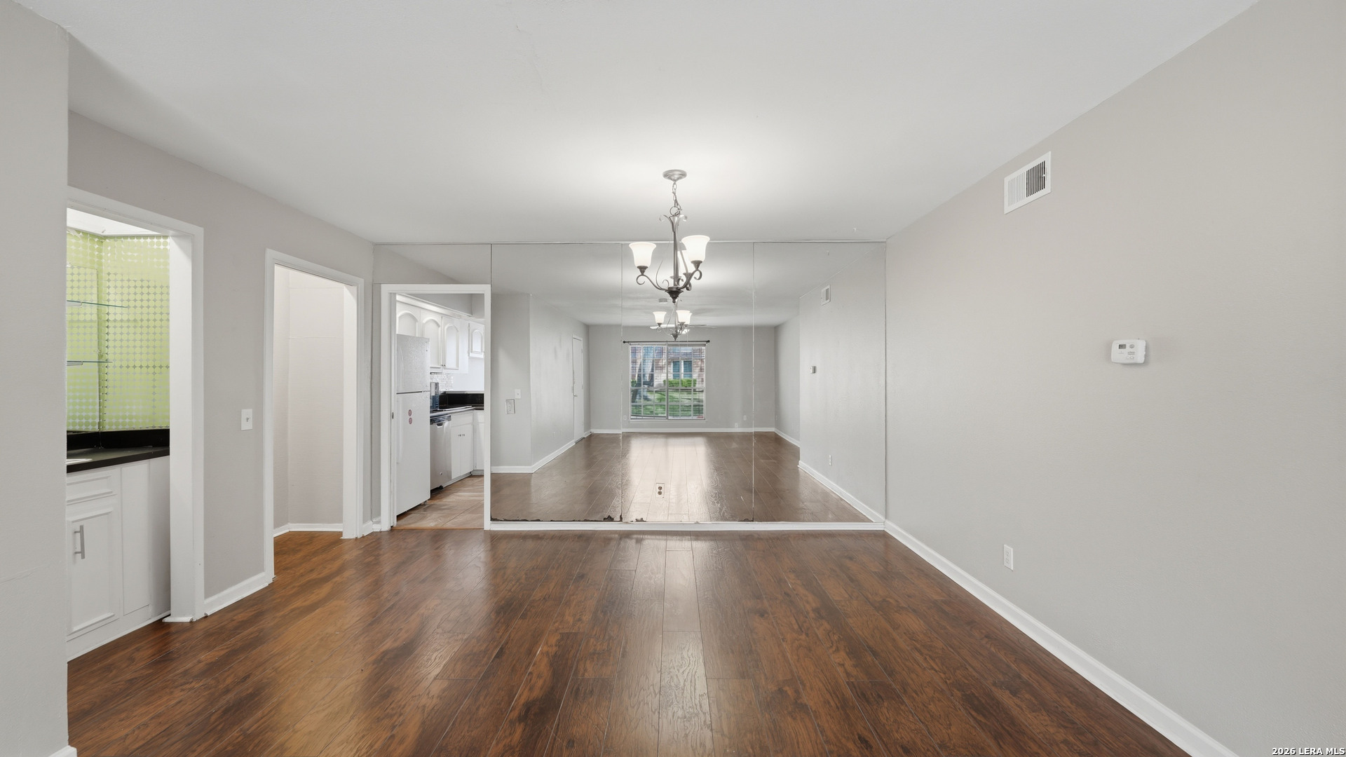 7500 Callaghan Road, Unit 140 San Antonio, TX 78229 - Photo 8 of 42 a view of an empty room with window and wooden floor
