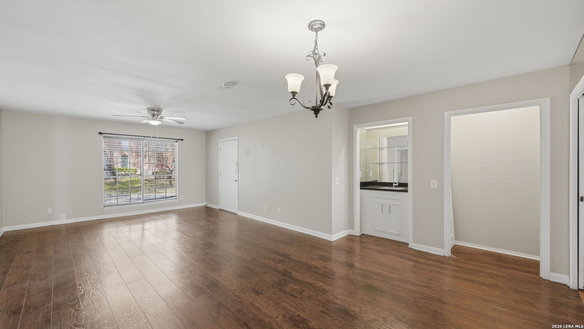7500 Callaghan Road, Unit 140 San Antonio, TX 78229 - Photo 10 of 42 a view of an empty room with wooden floor and a window