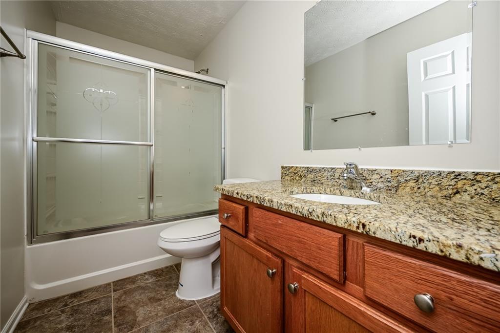 4468 Abram Way Conley, GA 30288 - Photo 16 of 23 a bathroom with a granite countertop sink toilet and shower