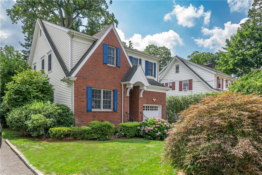 a front view of a house with a yard and potted plants