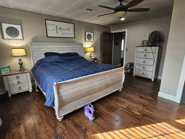 a bedroom with a bed and wooden floor