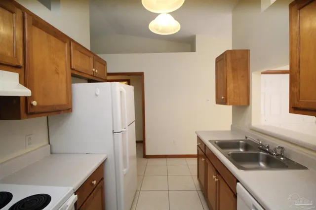 a kitchen with a sink a refrigerator and a stove