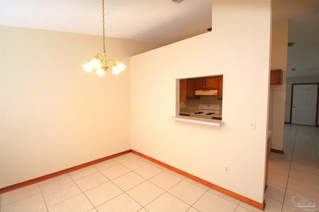 a view of a room with a chandelier fan and refrigerator