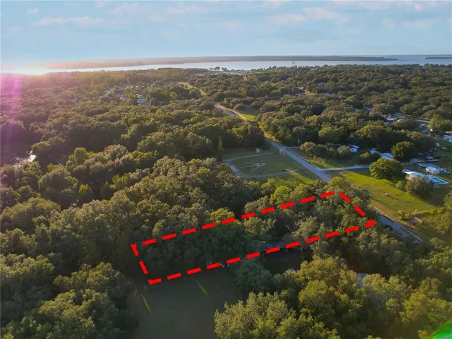 an aerial view of residential houses with outdoor space and lake view
