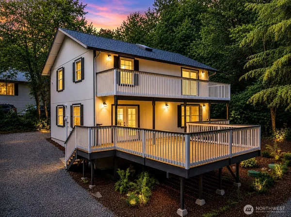 a view of a house with a wooden deck and furniture