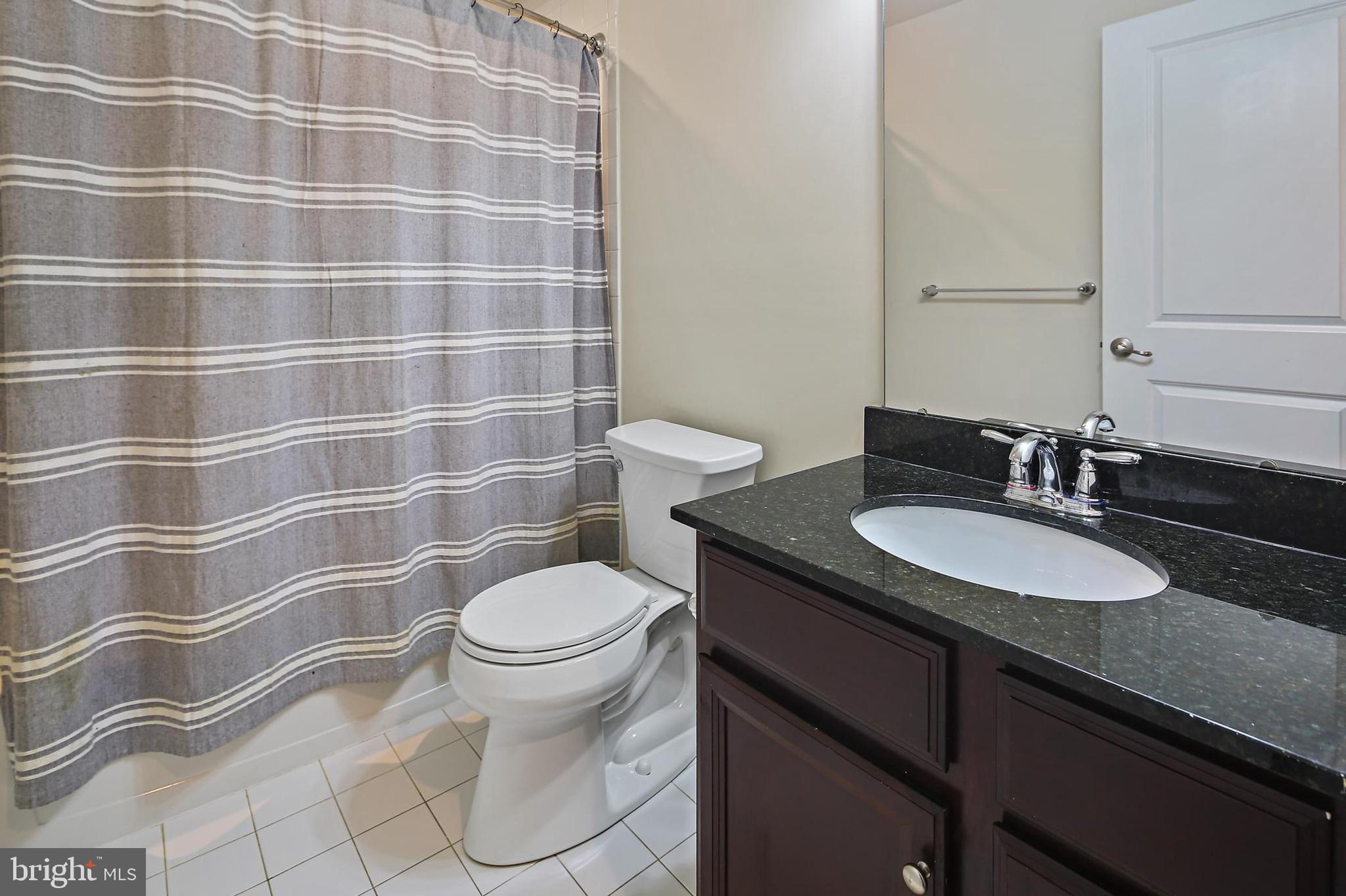 11675 Emerald Green Drive Clarksburg, MD 20871 - Photo 12 of 35 a bathroom with a granite countertop toilet a sink and a mirror