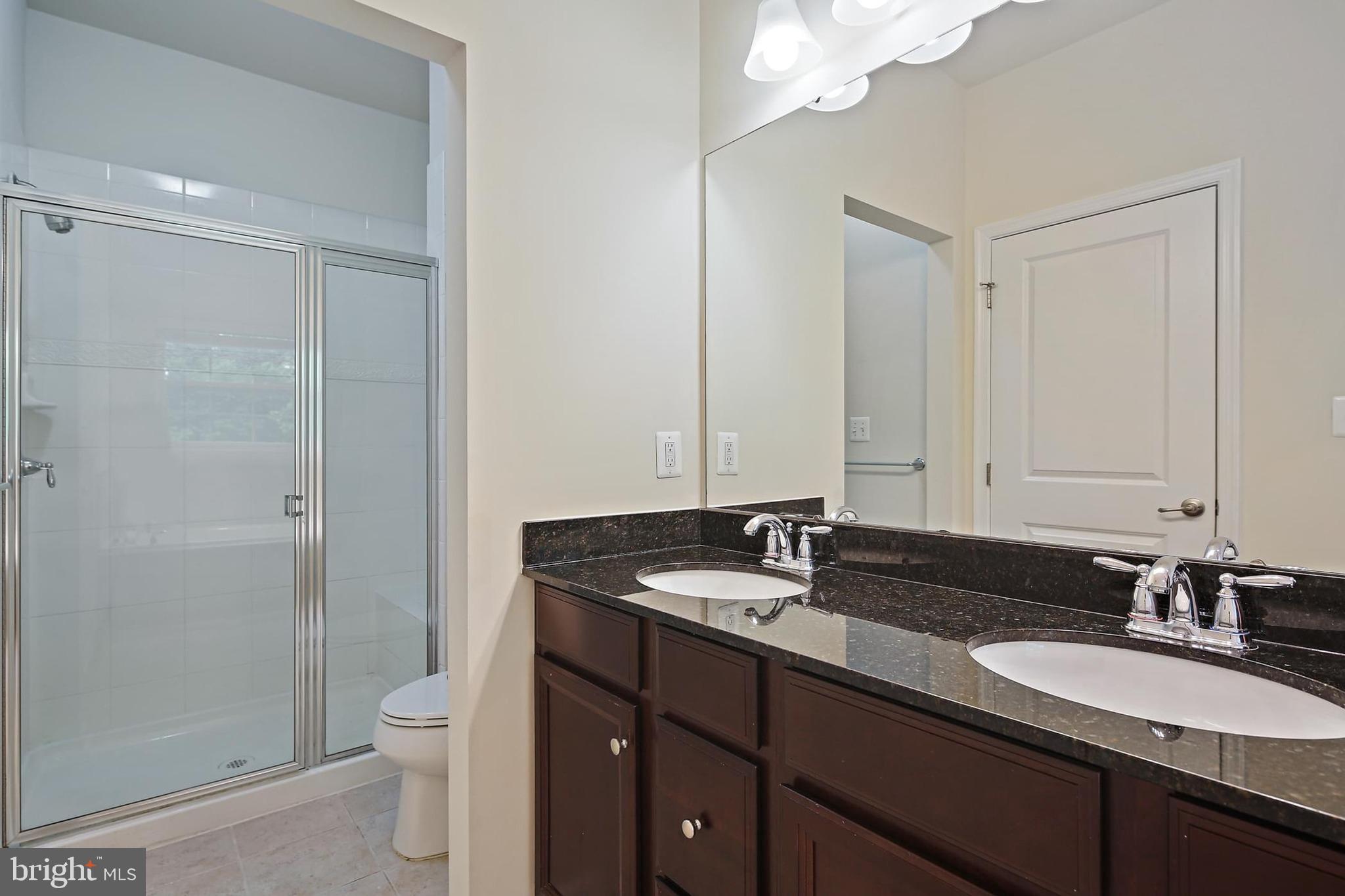 11675 Emerald Green Drive Clarksburg, MD 20871 - Photo 18 of 35 a bathroom with a granite countertop sink toilet and shower