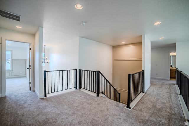 223 South Cottonwood Road, Unit 7501 Vineyard, UT 84059 - Photo 26 of 45 Carpeted upper-level landing featuring black metal railings and recessed lighting