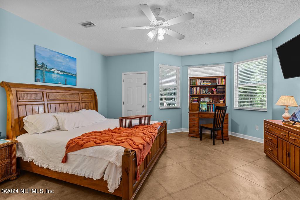 8225 Hardwood Landing Road St. Augustine, FL 32092 - Photo 21 of 126 a bedroom with a bed furniture a flat screen tv and a window