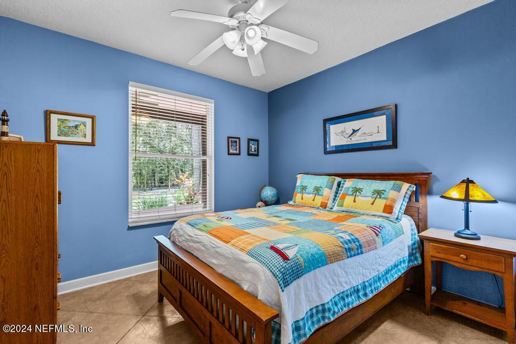8225 Hardwood Landing Road St. Augustine, FL 32092 - Photo 29 of 126 a bedroom with a bed and a chandelier