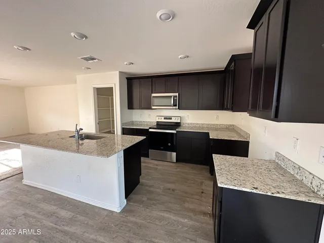 a kitchen with granite countertop a sink stove and refrigerator